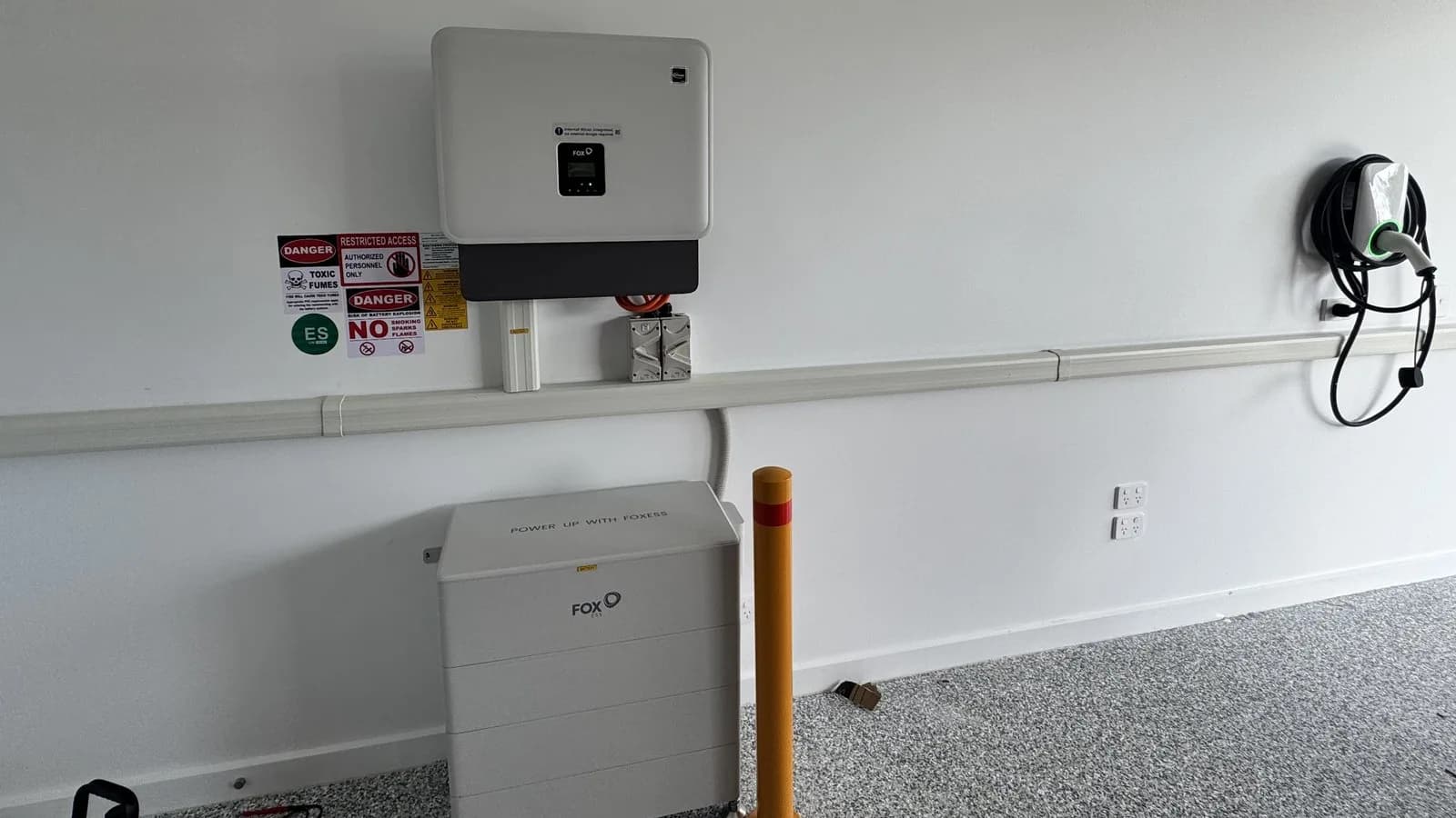 A Fox ESS hybrid inverter, CQ7 battery stack and EV charger on one garage wall, installed by Nuvolt