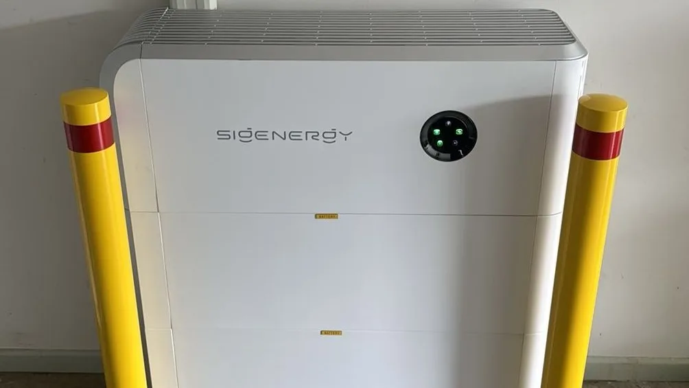A Sigenergy SigenStor battery stack between two safety bollards in a customer's garage, installed by Nuvolt