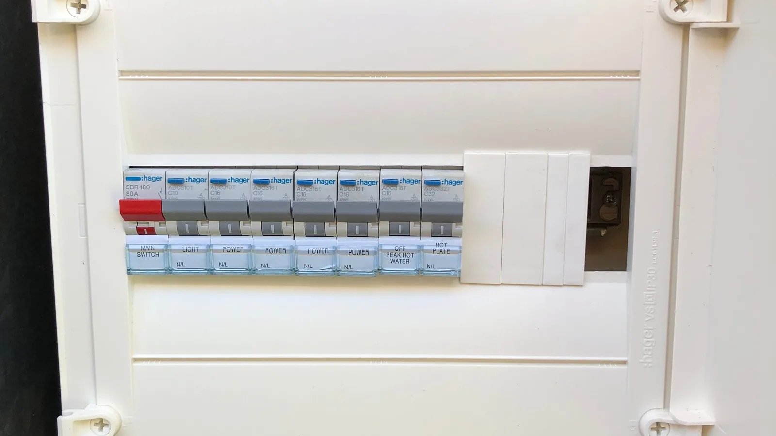 An upgraded residential switchboard with a row of labelled RCBOs and a main switch