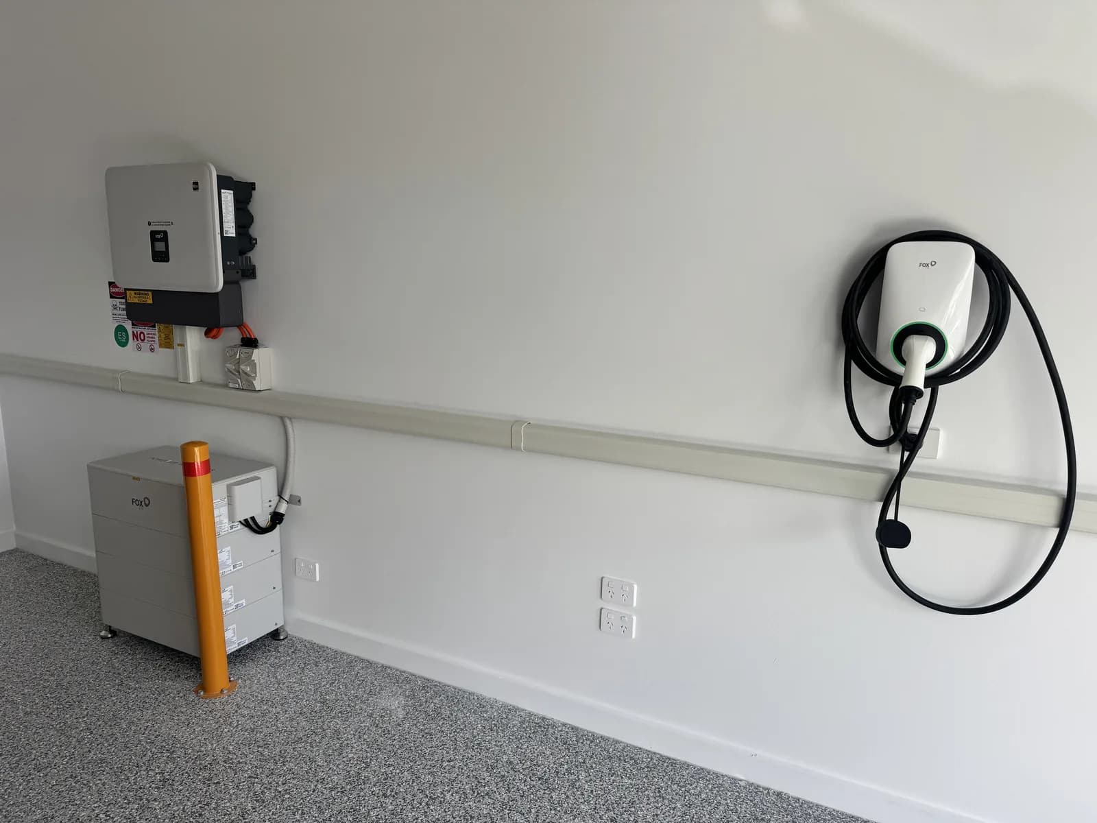 Nuvolt Electrical electrician with a 28kWh Fox ESS CQ7 battery, 15kW H3 three phase hybrid inverter and 22kW three phase EV charger installed in a garage