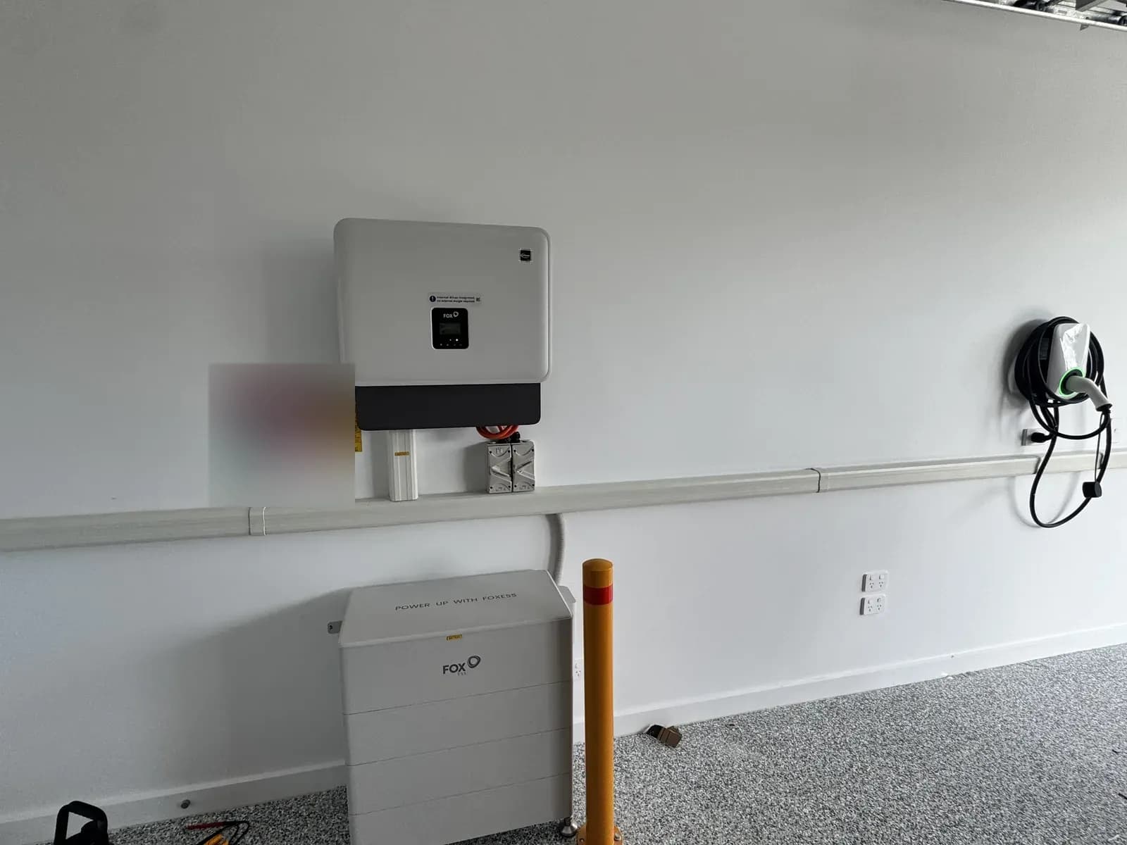 Nuvolt Electrical electrician with a 28kWh Fox ESS CQ7 battery, 15kW H3 three phase hybrid inverter and 22kW three phase EV charger installed in a garage
