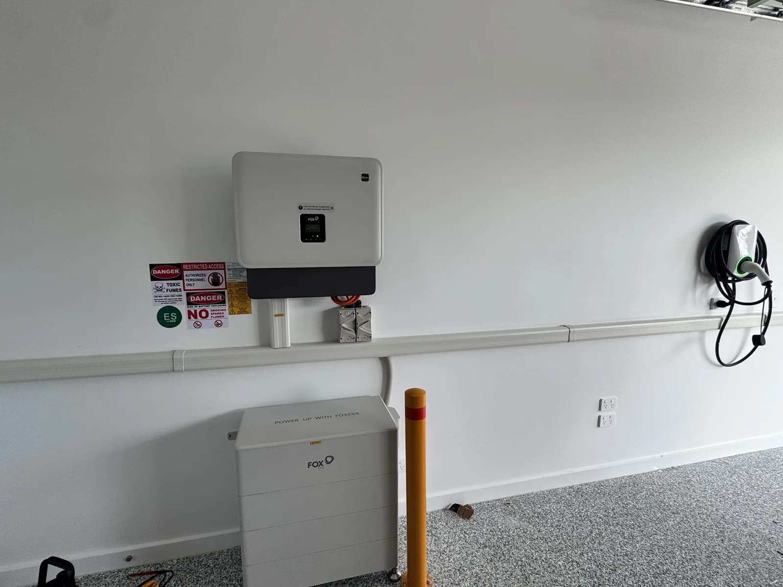 Nuvolt Electrical electrician with a 28kWh Fox ESS CQ7 battery, 15kW H3 three phase hybrid inverter and 22kW three phase EV charger installed in a garage