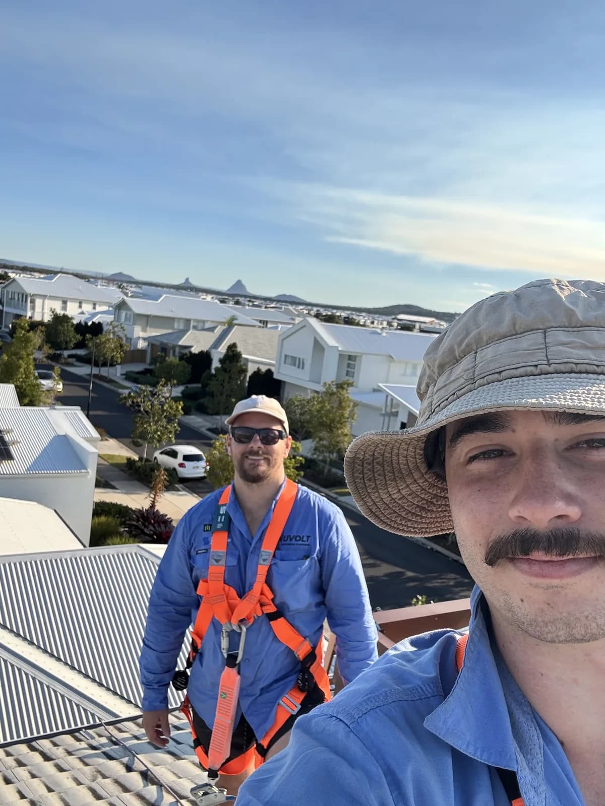 Nuvolt Electrical electricians in safety harnesses during a rooftop solar installation on the Sunshine Coast