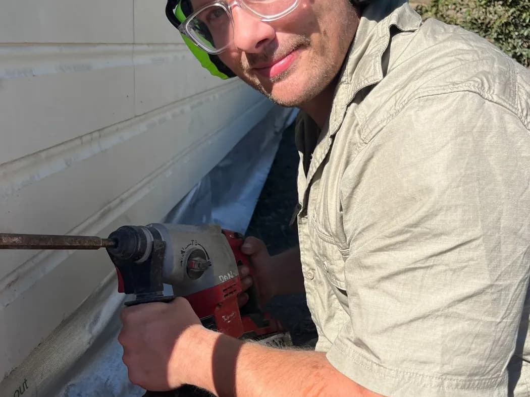 Nuvolt electrician drilling through the wall of a home to run new cable