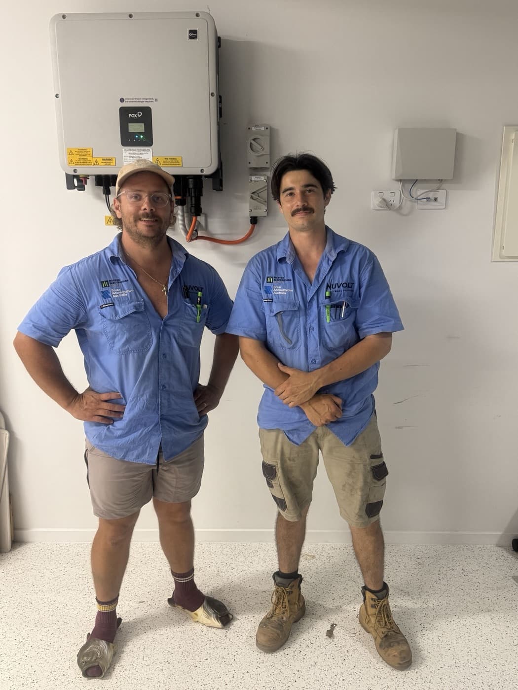 Nuvolt Electrical's SAA-accredited electricians beside a newly installed Fox ESS hybrid inverter