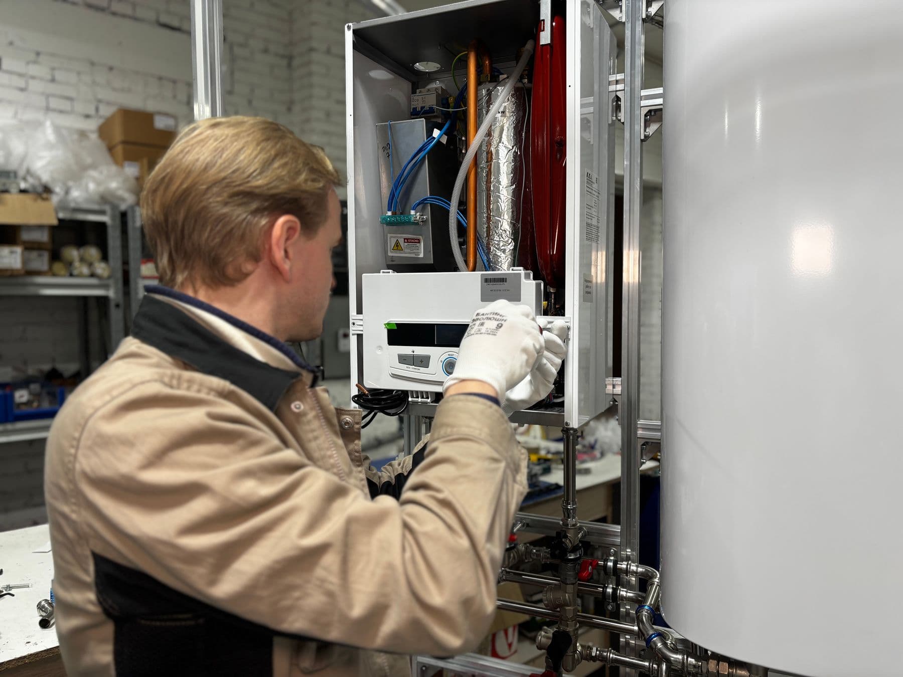 Technician working on the electrical controls of an electric hot water system