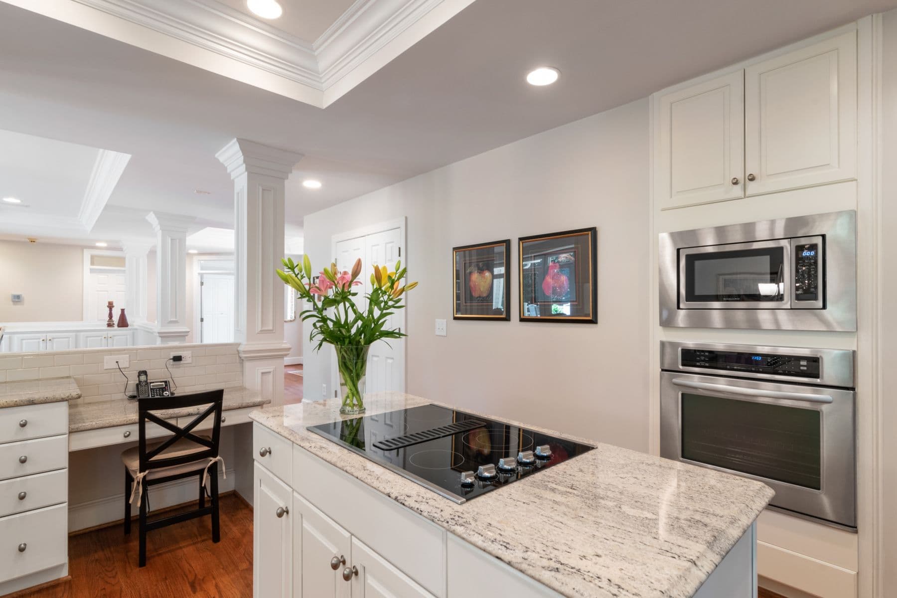 Modern kitchen island with glass cooktop and stainless steel wall oven