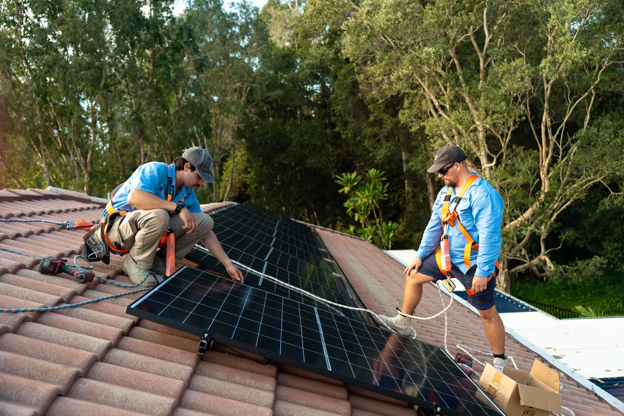 Dan and a Nuvolt team member laying solar panels on a tiled roof