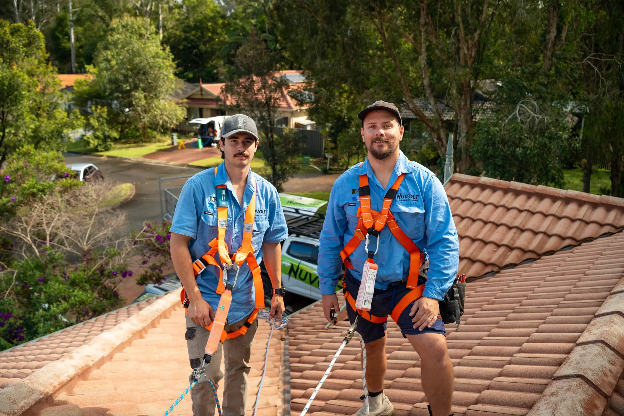 Dan and a Nuvolt team member in safety harnesses on a tiled roof