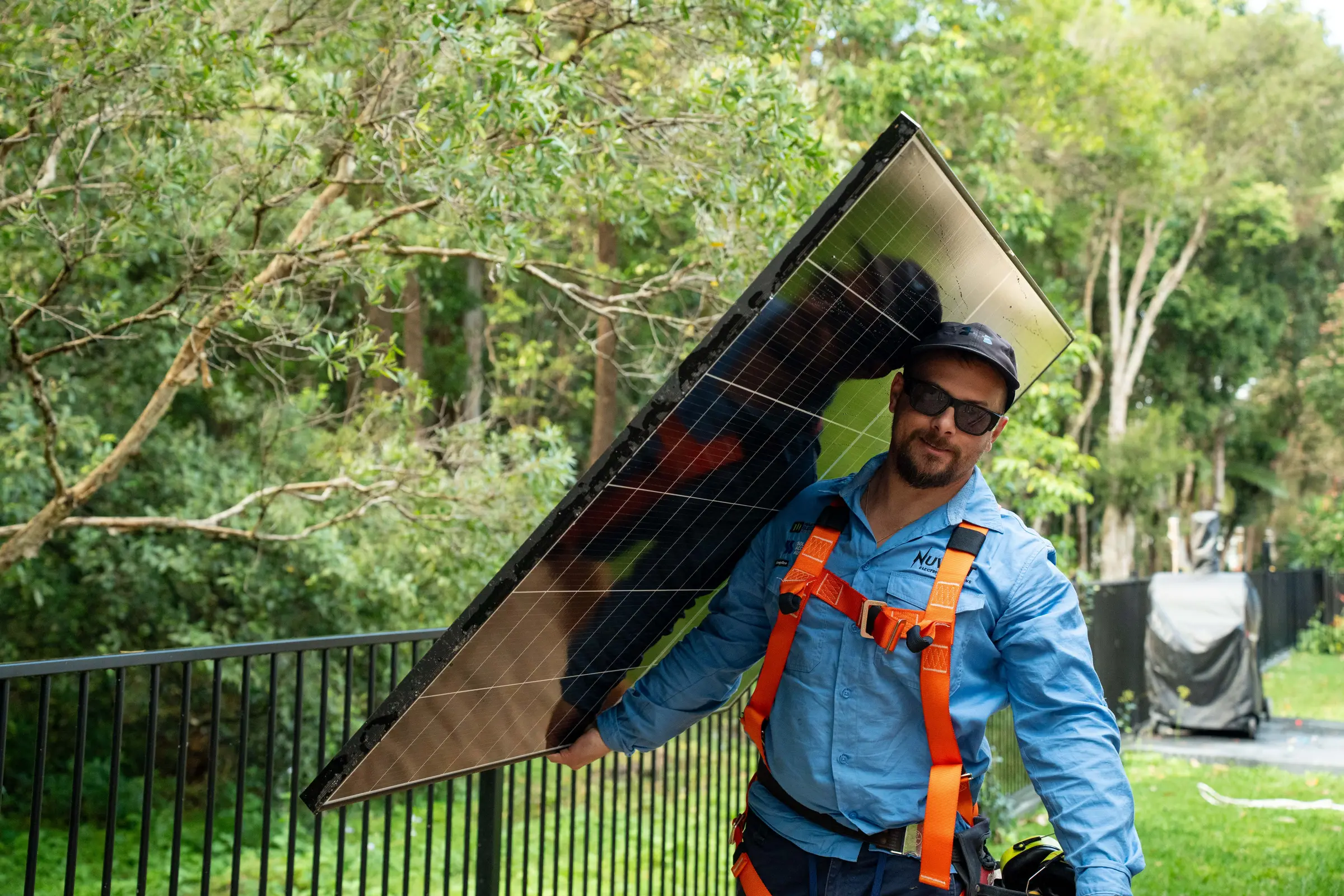 Dan from Nuvolt and a team member laying solar panels on a tiled roof on the Sunshine Coast