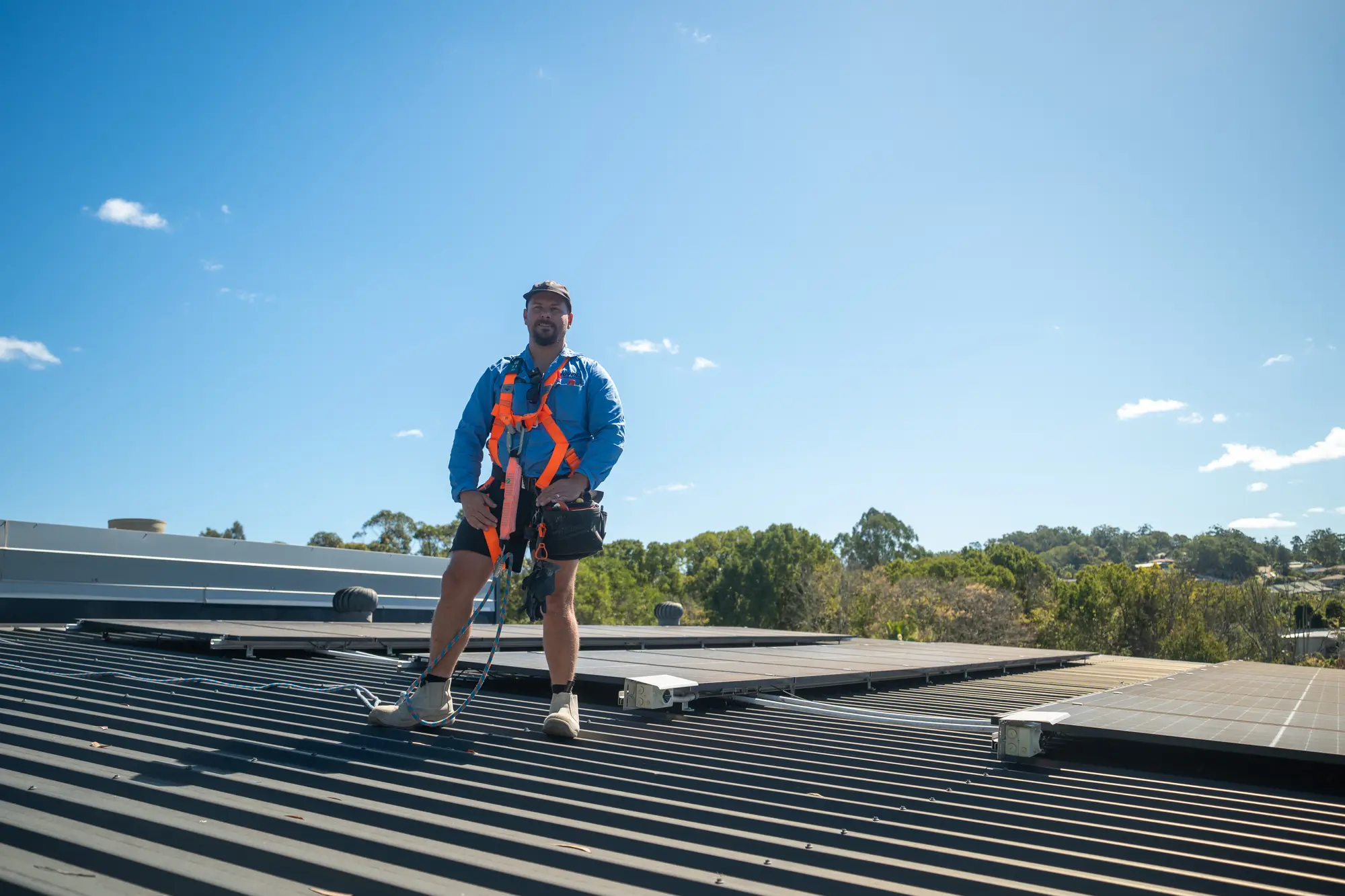 Daniel Carmont, Nuvolt's founder, standing in a safety harness on a roof among solar panels